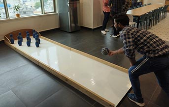 Adult guest enjoying a tabletop bowling challenge at an indoor party